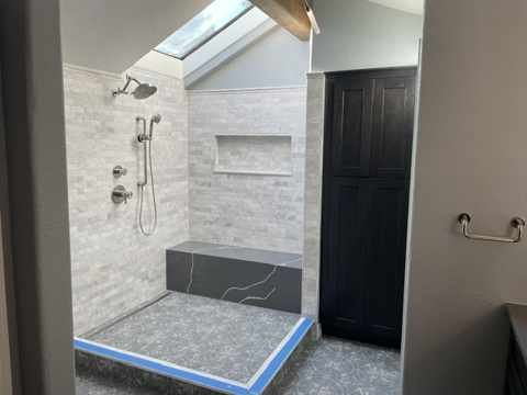 Remodeled shower with new tile, niche, and skylight in Centennial, CO primary bathroom