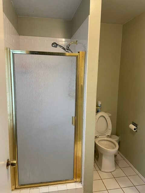 Dated bathroom with glass shower door before remodel in Denver, CO